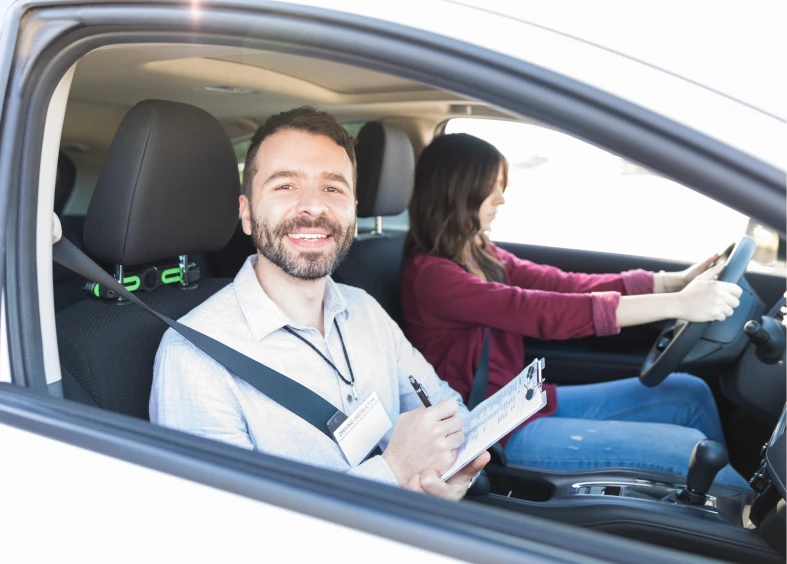 Driving instructor with clipboard, student driving car.